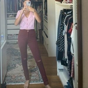 Burgundy skinny jeans with distress rips​